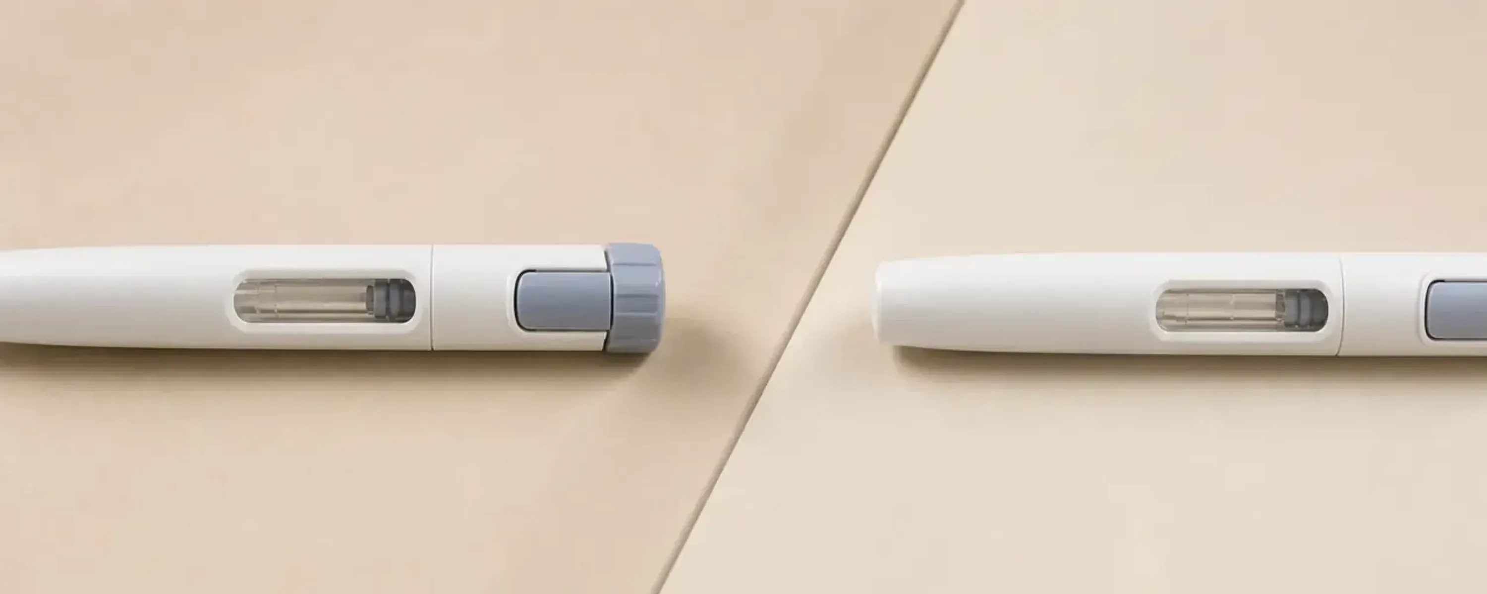 Two identical unbranded prefilled injection pens on a clean neutral surface, illustrating a head-to-head comparison between semaglutide and tirzepatide.